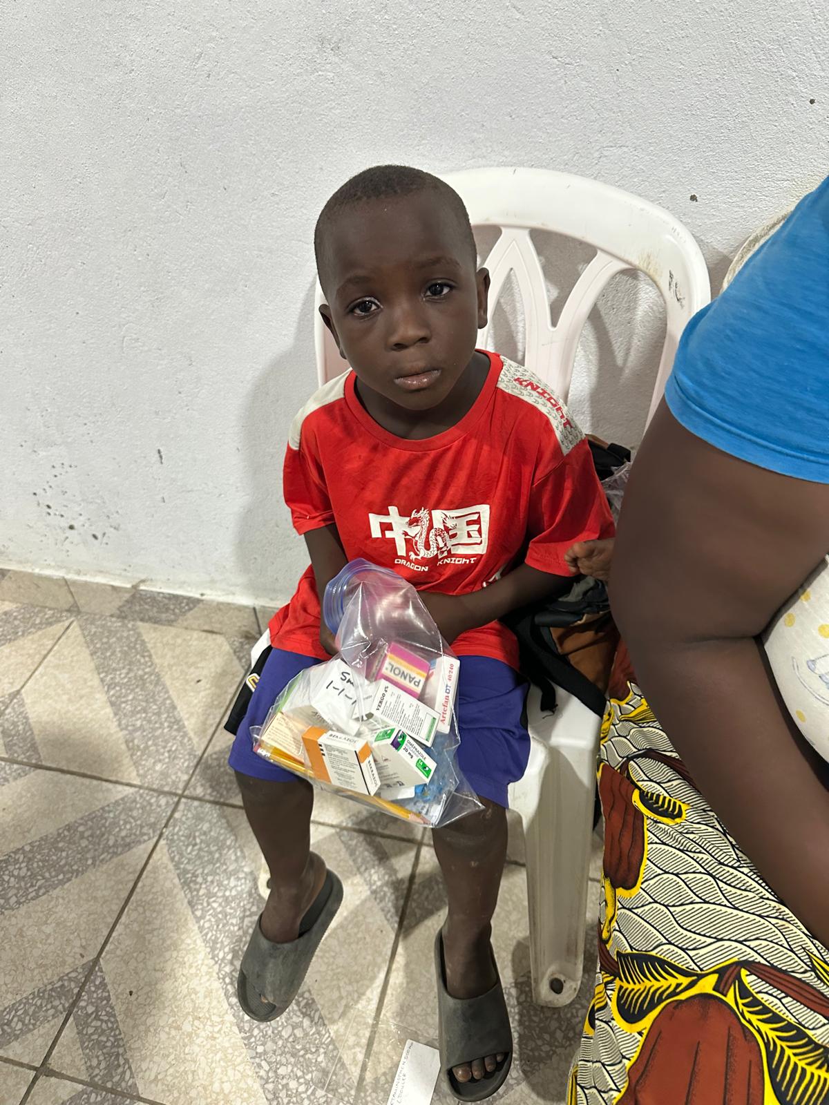 A young boy holding his medicine