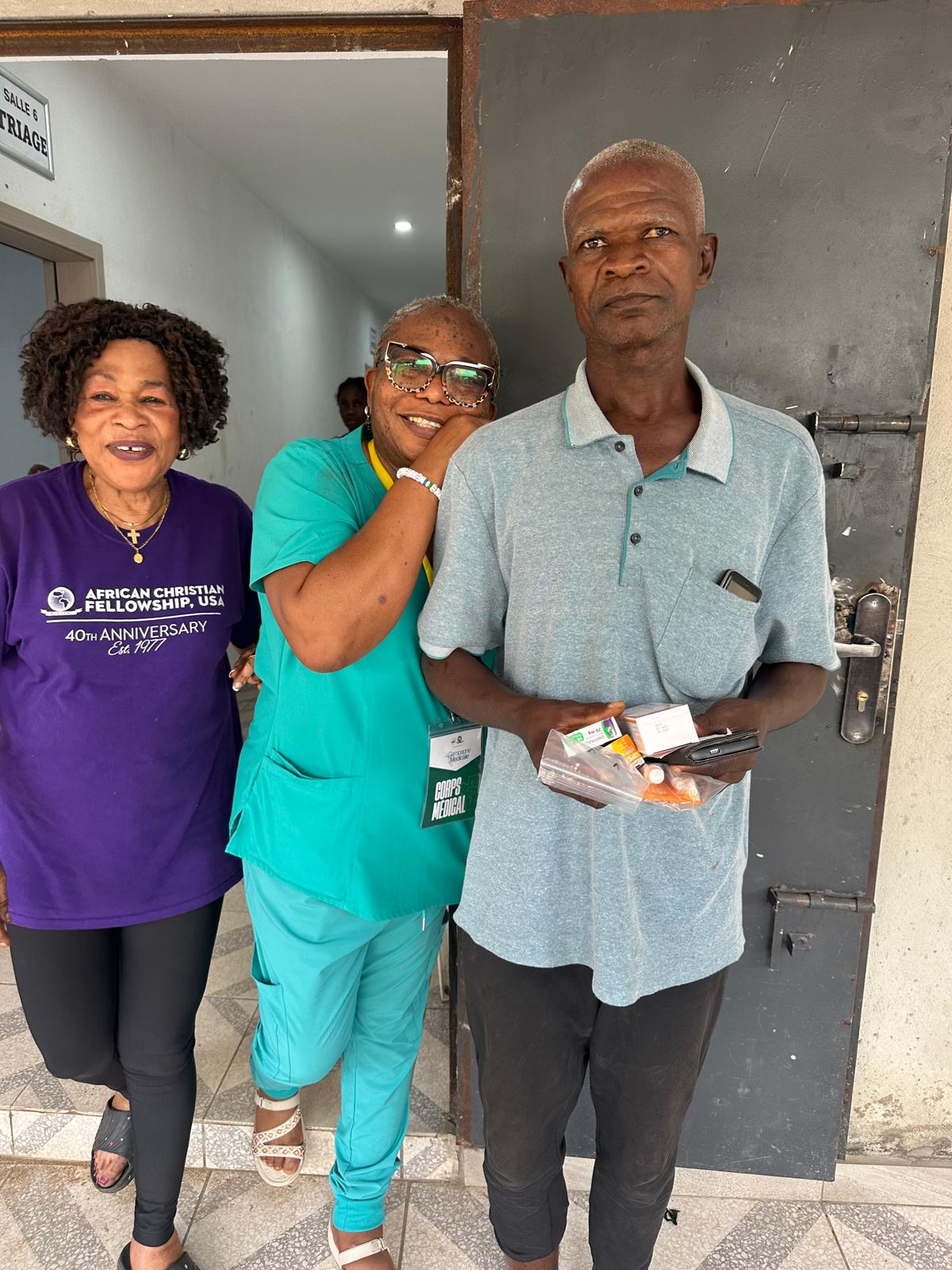 Team members with a man holding his medicine